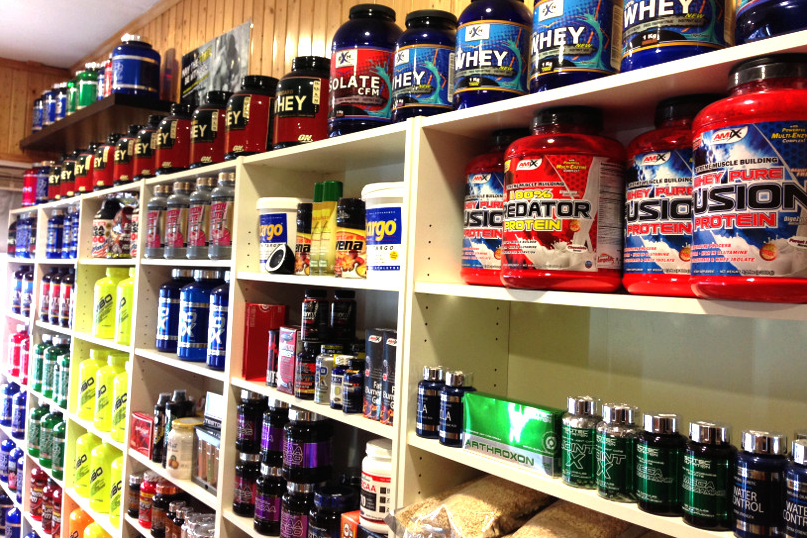 a shelf with many bottles of protein